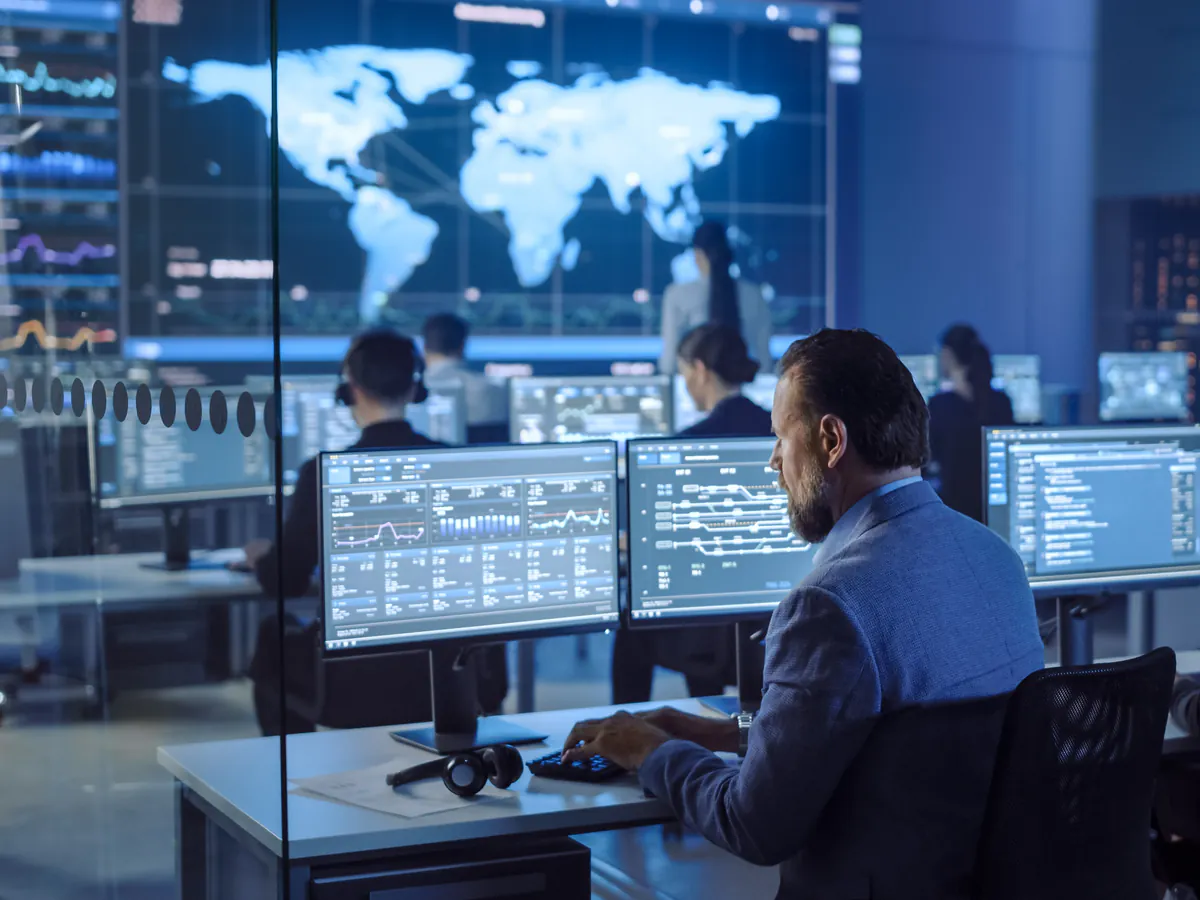 Equipo de análisis supervisa datos e indicadores desde un centro de operaciones digitales.