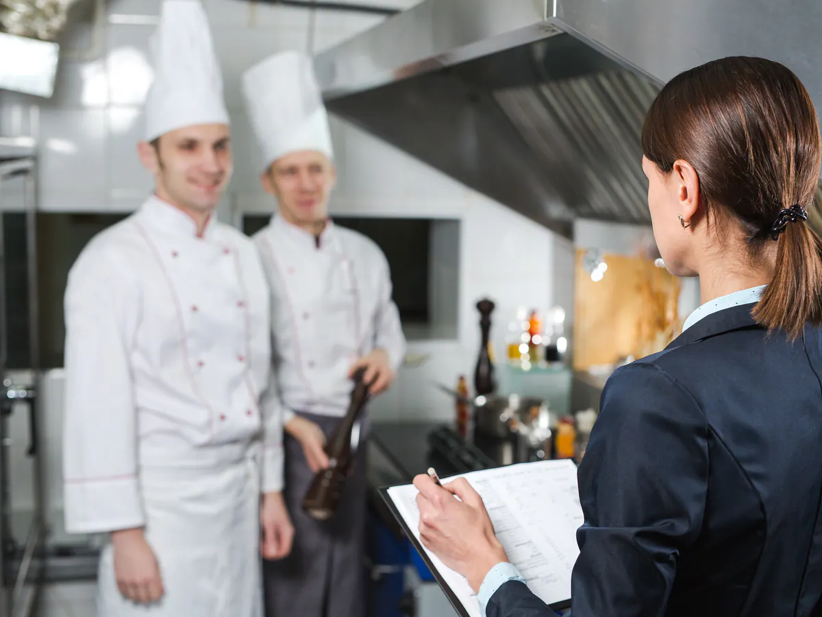 Gerente coordina al equipo de cocina dentro de una infraestructura digital para restaurantes multisucursal.